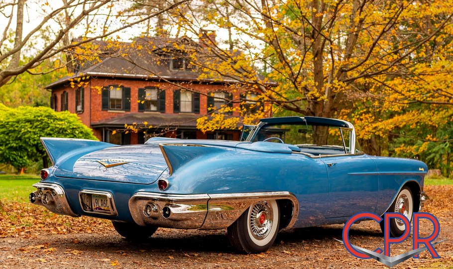 Tailfin view of a top-down restored 1957 Cadillac Eldorado Biarritz finished in Bahama Blue